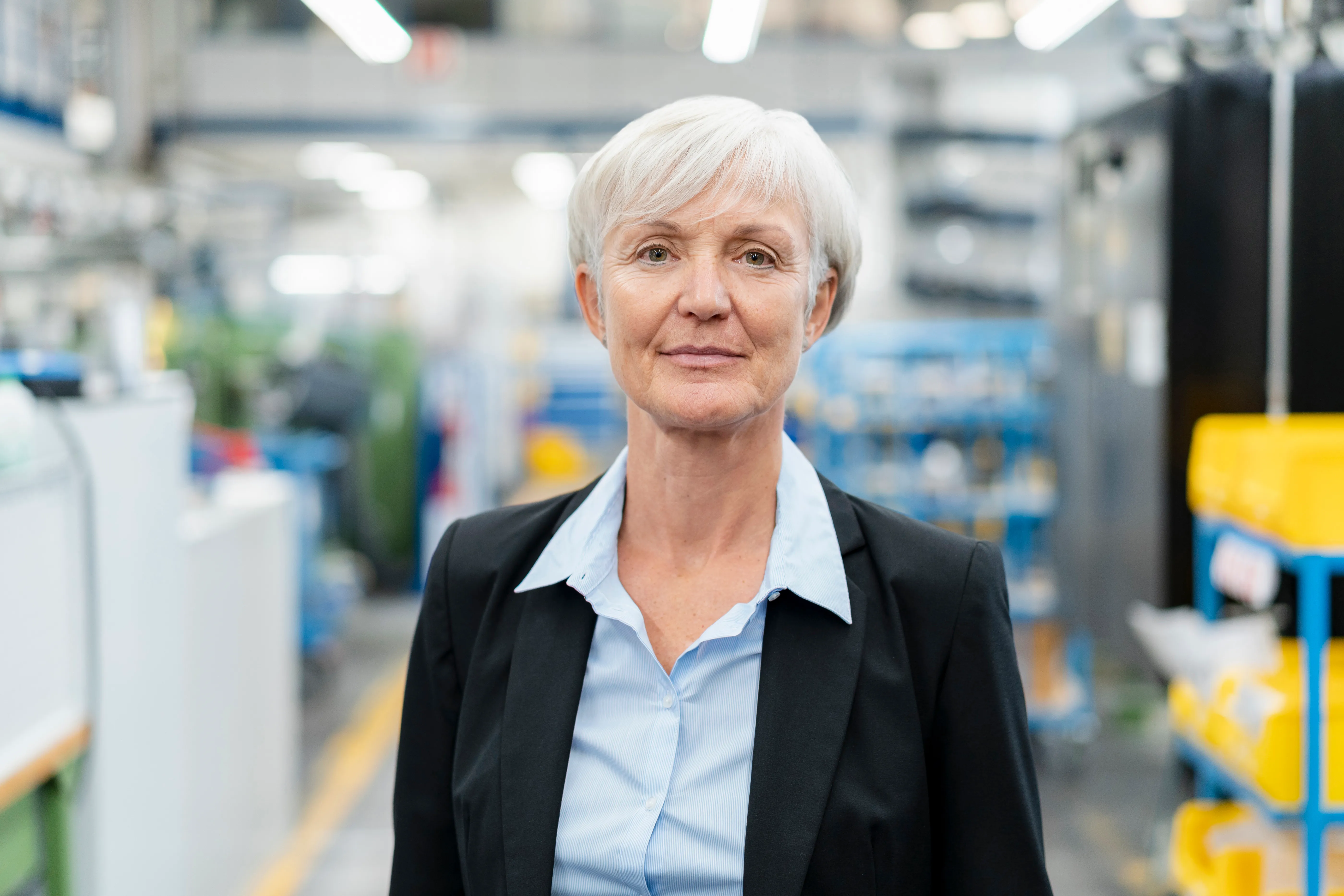 A senior plant leader on her factory floor, looking straight at the camera.